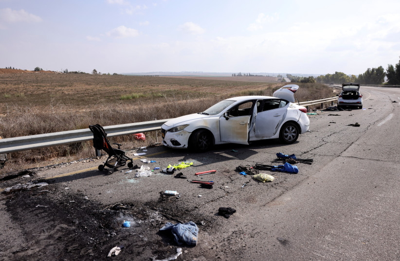 Personal belongings including a child's pram are seen on the road next to a car days after a mass infiltration by Hamas terrorists from the Gaza Strip, near Kibbutz Kfar Aza, in southern Israel, October 10, 2023 (credit: RONEN ZVULUN/REUTERS)