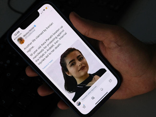 A person in Cairo looks on October 20, 2022 at a tweet about the reported death of 15-year-old Iranian girl Asra Panahi. - The 15-year-old Iranian girl died last week after being beaten during a raid by the security forces on her school, a teachers' union said, urging the authorities �K